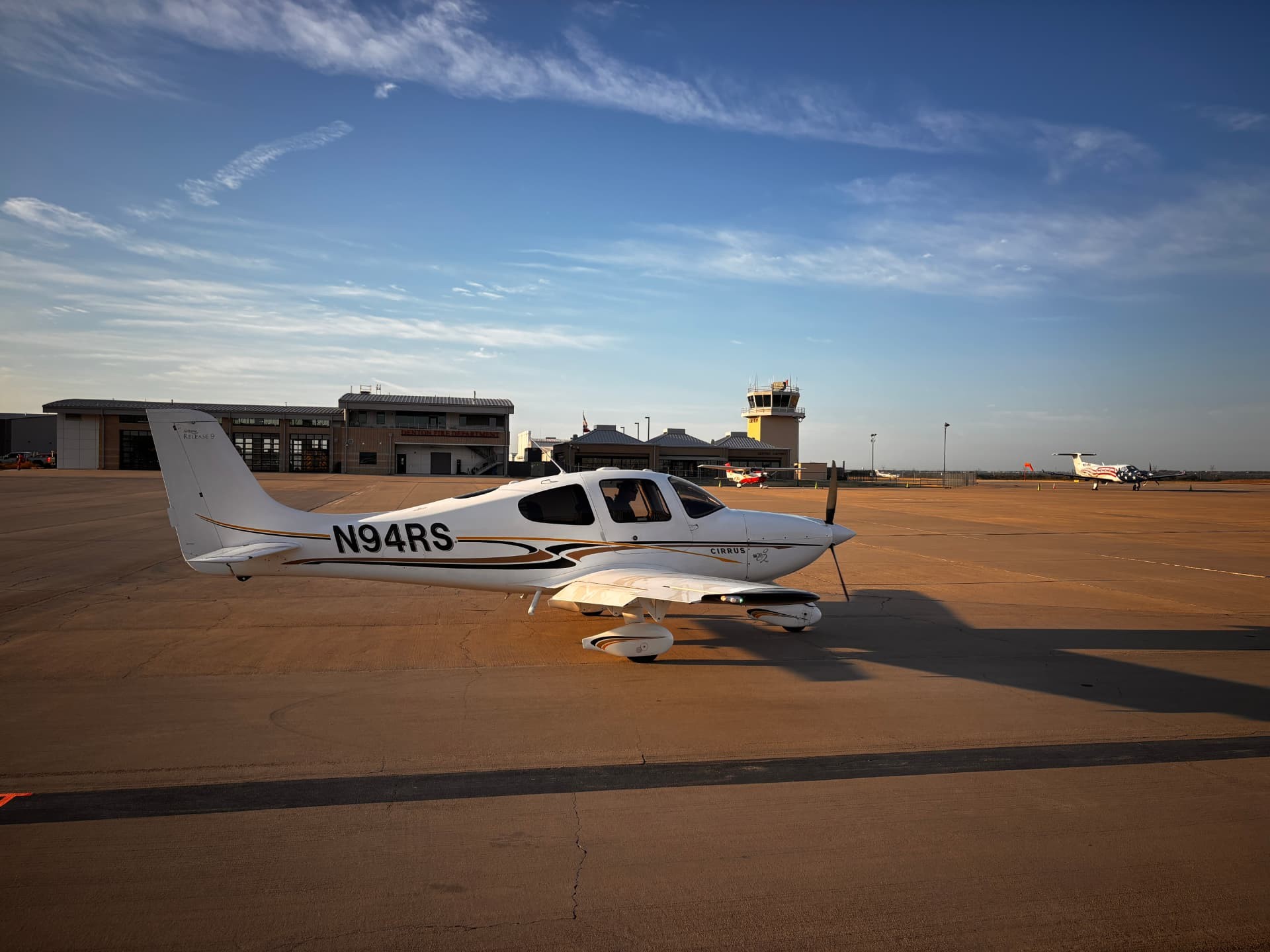 Cirrus N94RS on the ramp with the Denton control tower behind it