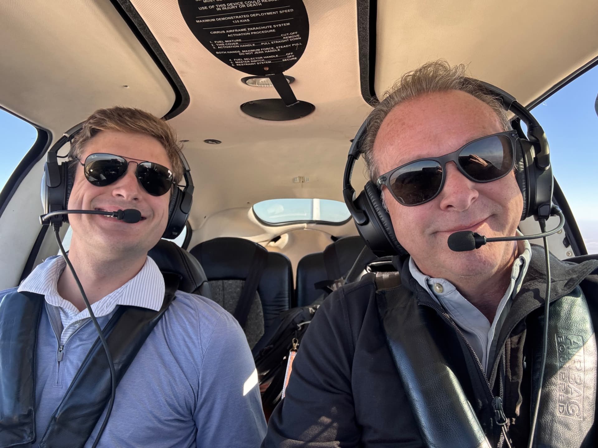 Two people enjoying a flight together, wearing headsets in the cockpit