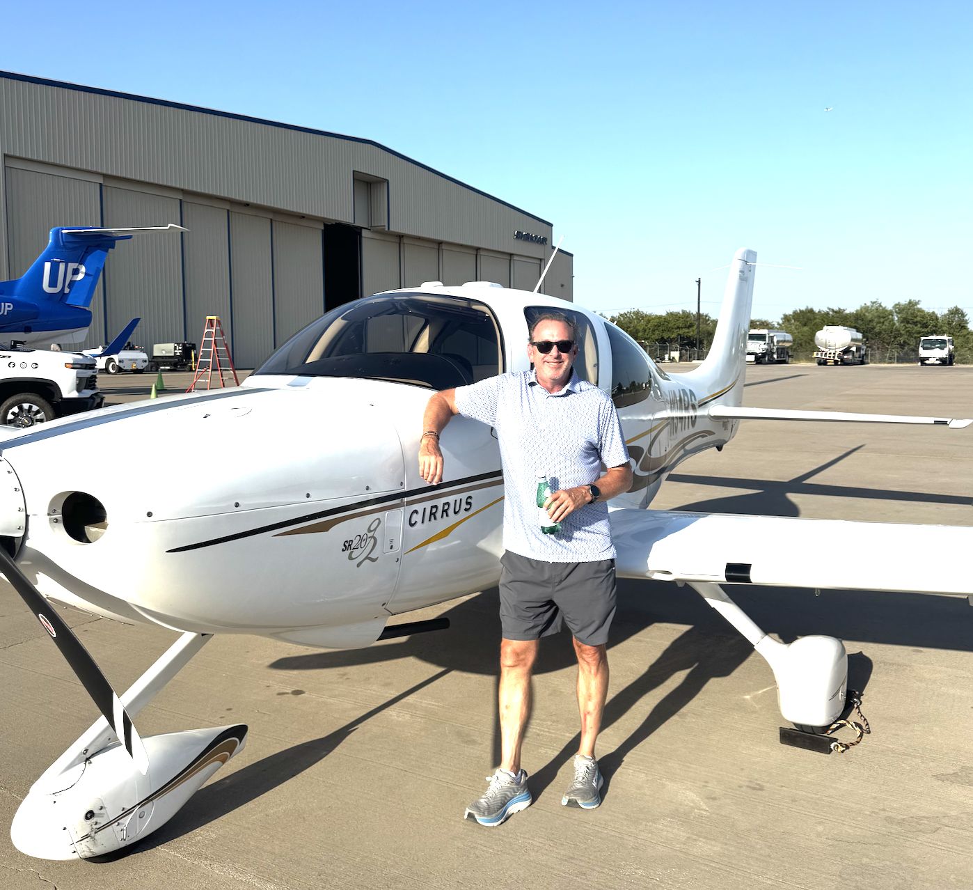 Club member leaning on the nose of a Cirrus SR20 on the ramp