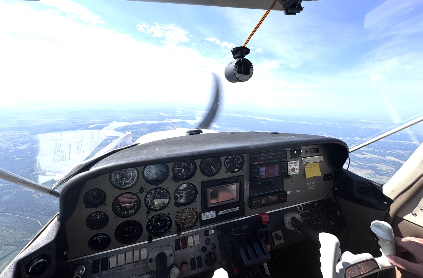 Steam-gauge instrument panel with an action camera mounted and the propeller spinning outside